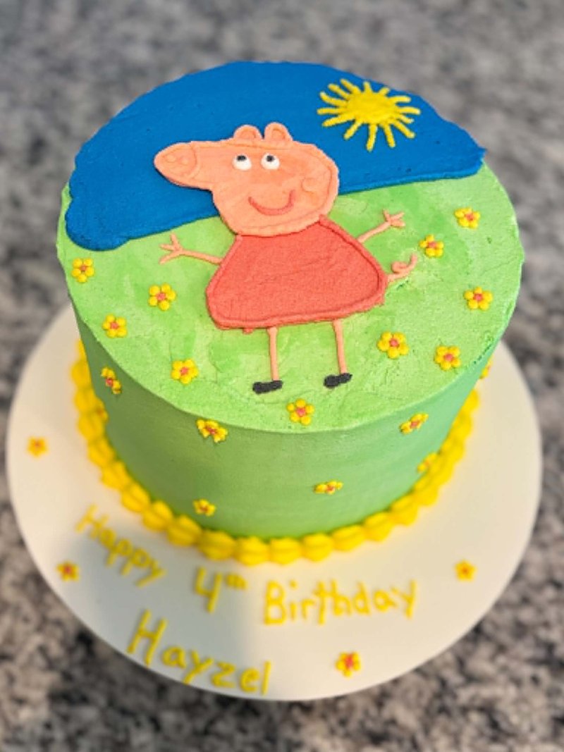 Green-grass-and-blue-sky themed cake with a Peppa Pig figure on top, yellow flowers scattered around, and Happy 4th Birthday lettering