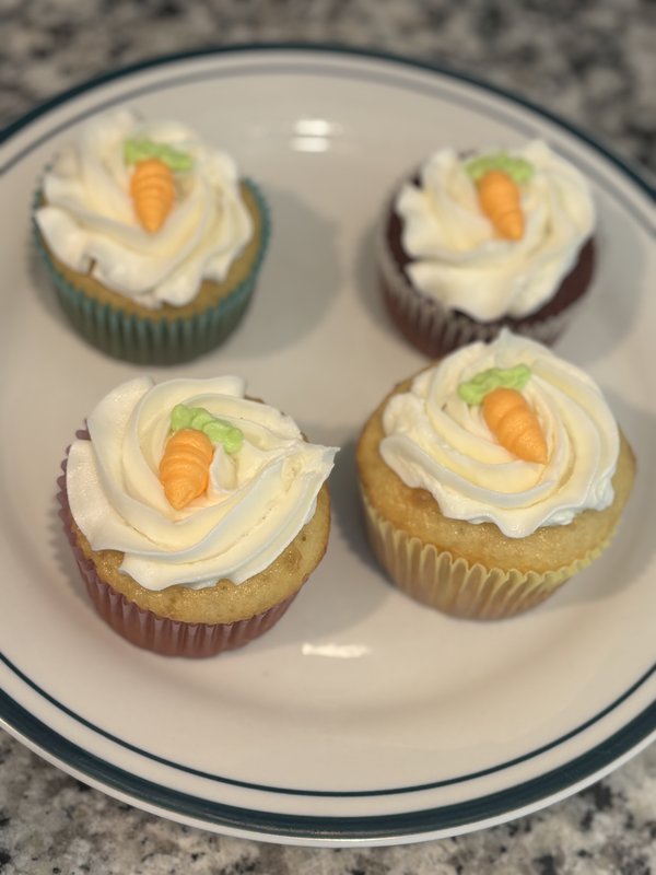 Carrot cake cupcakes with cream cheese frosting rosettes and tiny fondant carrots