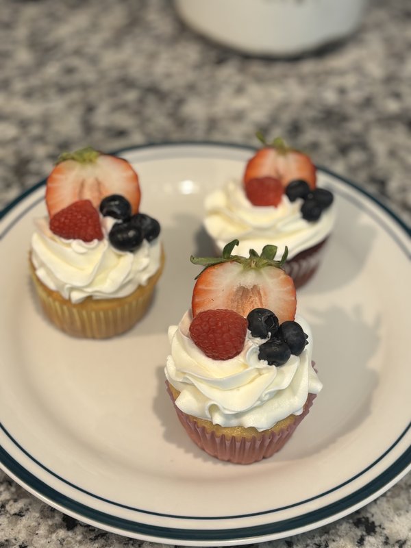 Vanilla cupcakes topped with fresh strawberries, blueberries, and raspberries