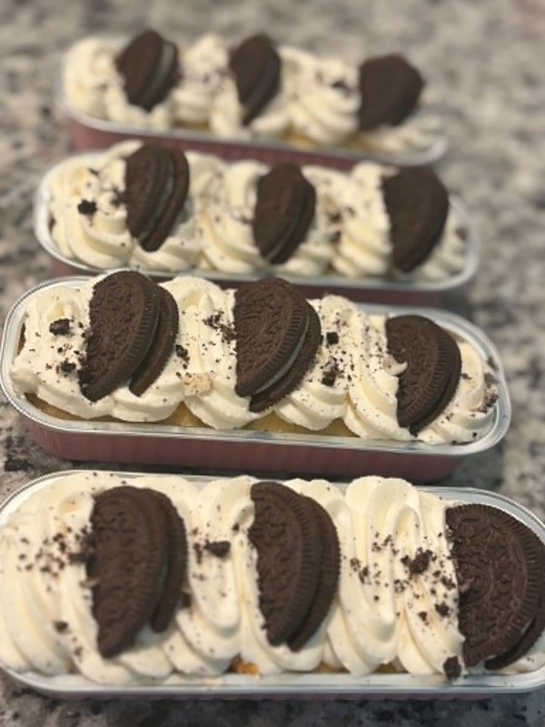 Stack of Oreo dessert cups with creamy white frosting and chocolate cookie pieces